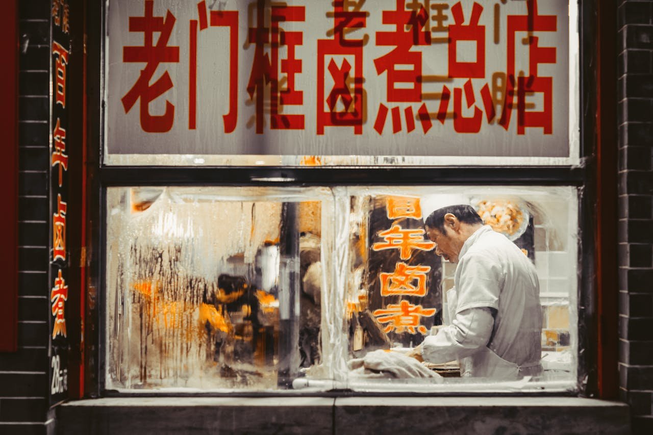 Chef working in a traditional Beijing restaurant kitchen, showcasing authentic Chinese cuisine.